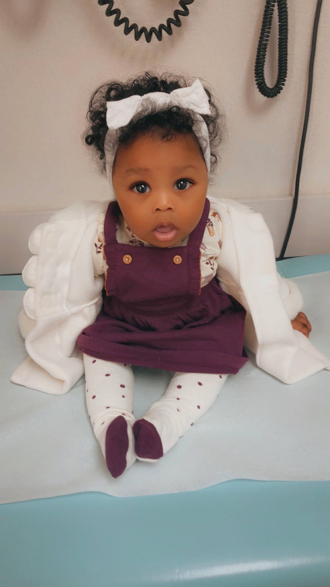 Saniyah is registered to the contest to win money with this photo: baby, baby_toddler_clothing, button, costume_accessory, embellishment, hair_accessory, headband, headpiece, person, sock, surprise, toddler