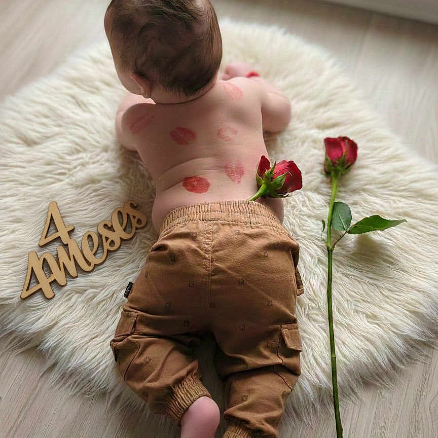 Ozziel joined the competition — help win amazing prizes! age_marker, baby, baby_skin, back_view, brown_pants, child, cute, decor, floor, fluffy_rug, indoors, infant, lying_down, natural_light, newborn, red_rose, rose_petals, skin, soft_texture, wooden_sign