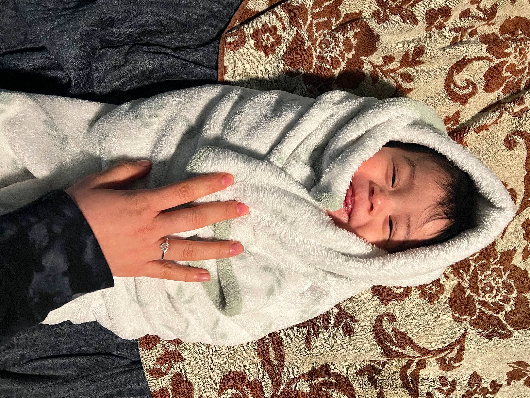Sneijder is registered to the contest to win money with this photo: baby_sleeping, bedding, bedtime, child, comfort, finger, flooring, fur, gesture, grey, human_body, linens, nap, outerwear, pattern, person, sleeve, textile, tree, wood
