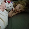 child, sleeping, stuffed_animal, blanket, bed, hand, cozy, soft_toy, comfort, rest, cute, indoor, peaceful, pajamas, face, hair, relaxation, close_up, cuddle, nap