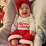 Maesyn is registered to the contest to win money with this photo: baby, smiling, red_bow, christmas, holiday, festive_clothing, blanket, cozy, infant, cute, happy, red_pants, white_shirt, headband, indoor, decorations, feet, hands, portrait, child