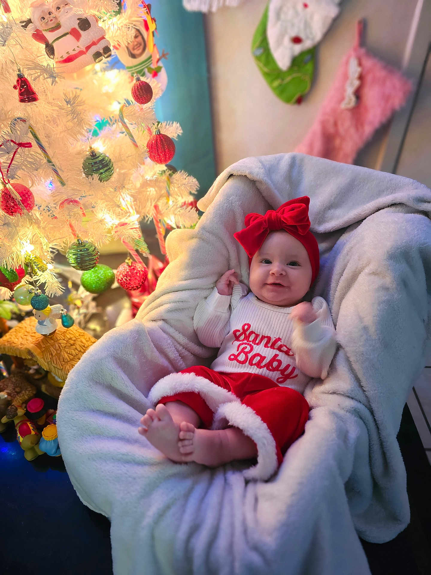 Maesyn joined the competition — help win amazing prizes! baby, christmas_tree, ornaments, holiday, festive, red_bow, blanket, smiling, infant, decorations, white_tree, candy_cane, stocking, plush_chair, cozy, indoors, cute, celebration, christmas, happy