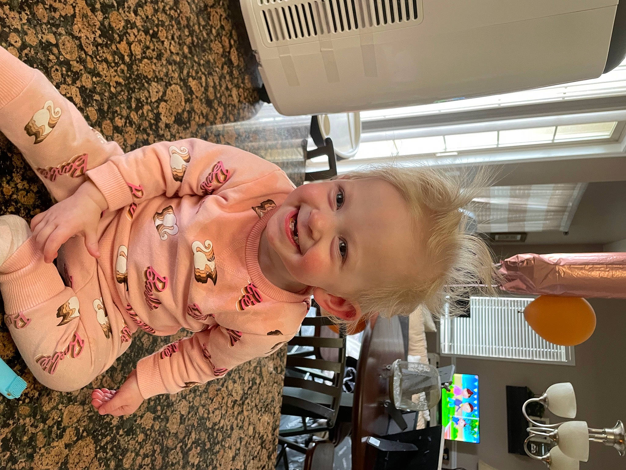 Indy is registered to the contest to win money with this photo: abdomen, baby, baby_toddler_clothing, child, eye, flesh, fun, happy, human_leg, joy, pattern, person, plant, room, smile, t_shirt, toddler, wood, wrist