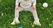 Phoebe joined the competition — help win amazing prizes! child, toddler, grass, greenery, dandelion, flower, ball, toy, smiling, happy, outdoor, nature, playing, casual_clothing, pink_bow, shoes, sitting, sunlight, portrait, cute