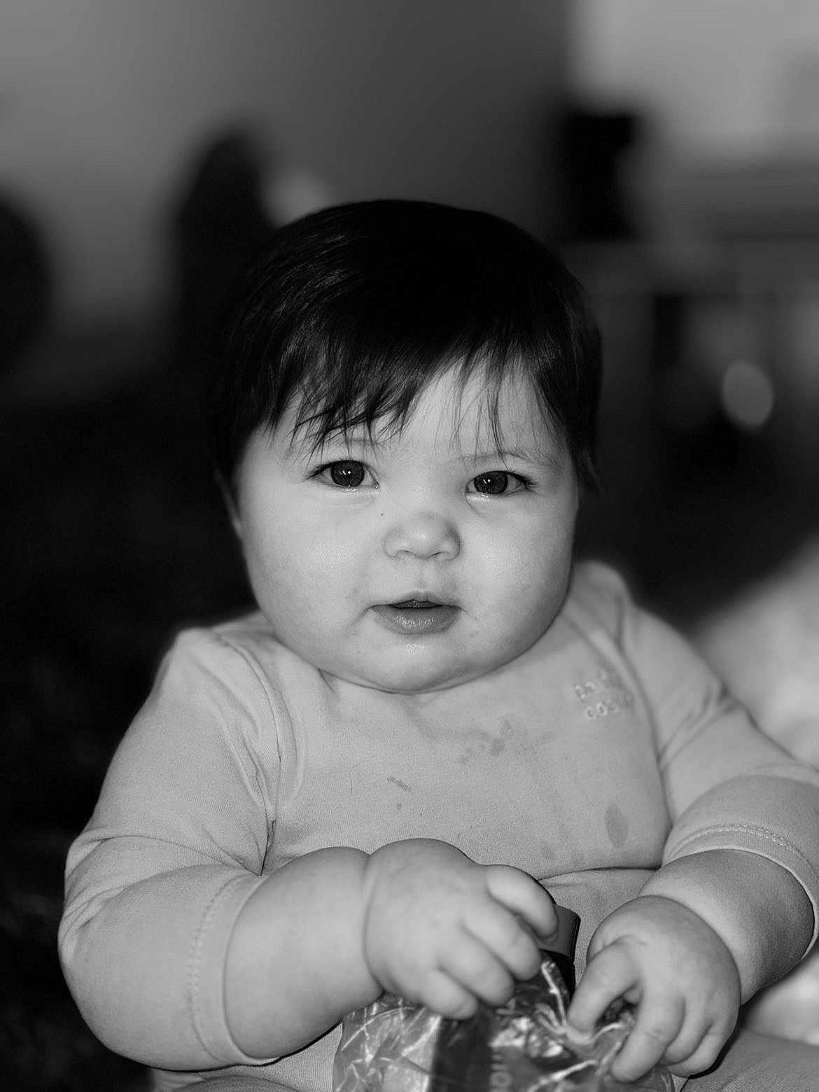 Rachel participe au concours pour gagner de l'argent avec cette photo : baby, child, face, hands, dark_hair, black_and_white, portrait, cute, expression, infant, clothing, holding, plastic_pouch, chubby_cheeks, skin, eyes, sitting, indoors, soft_lighting, closeup