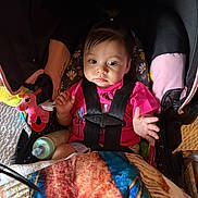 Marisol joined the competition — help win amazing prizes! baby, blanket, bottle, car_seat, child, cozy, cute, expression, face, hair, hand, indoor, infant, person, pink_shirt, portrait, seatbelt, sitting, toy, unicorn