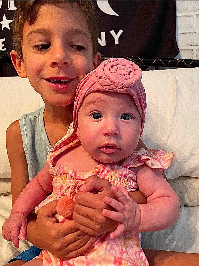 Stevie joined the competition — help win amazing prizes! baby_toddler_clothing, cheek, eye, eyelash, finger, forehead, gesture, hand, happy, head, headwear, human_body, iris, joy, lip, mouth, neck, nose, person, pink