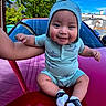 baby, child, smile, hooded_clothing, car, red_car, outdoor, blue_sky, tree, greenery, infant, sitting, cute, person, sock, holding, happy, portrait, sunny, daytime