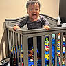 Yael is registered to the contest to win money with this photo: baby, bedding, bedroom, blanket, cartoon, child, colorful, crib, dark_hair, family, happy, home, indoor, infant, nursery, portrait, railing, smiling, standing, toy