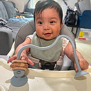 Yael joined the competition — help win amazing prizes! baby, bibs, blue_toy, child, couch, curtains, face, furniture, happy, high_chair, indoor, infant, living_room, person, play, seat, smiling, toy, window, wooden_rings