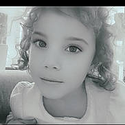 Layana participe au concours pour gagner de l'argent avec cette photo : black_and_white, calm, casual, child, closeup, couch, curly_hair, cute, earrings, expression, eyewear, face, head_and_shoulders, indoor, person, portrait, resting, smile, soft_lighting, young