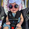 baby, child, sunglasses, car_seat, bow, smile, infant, seat_belt, clothing, denim, pink, floral, safety, cute, headwear, accessory, happy, portrait, indoors, person