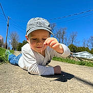 Nolan joined the competition — help win amazing prizes! baby, baseballcap, bodypart, cap, city, clothing, face, finger, grass, hand, hat, head, pants, person, photography, plant, portrait, road, sitting, street