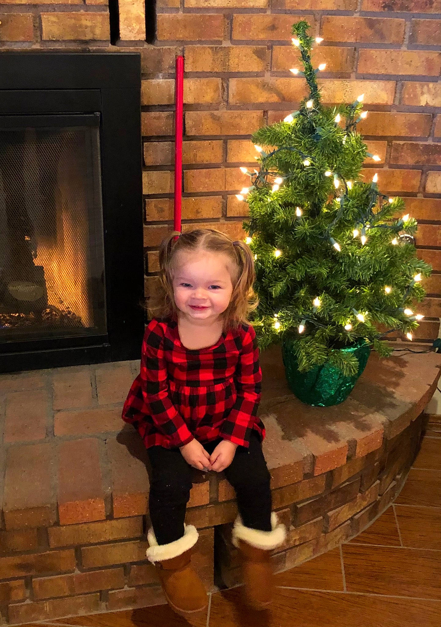 Saige joined the competition — help win amazing prizes! christmas, christmas_decoration, christmas_ornament, christmas_tree, evergreen, gas, holiday, holiday_ornament, house, joy, leaf, ornament, person, photograph, plaid, plant, red, smile, standing, tartan