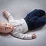 Daniel is registered to the contest to win money with this photo: baby, infant, child, lying_down, onesie, pants, blue_pants, white_onesie, airplane_prints, soft_surface, looking, wide_eyes, calm_expression, cute, small_hands, bare_feet, casual_clothing, indoors, portrait, human