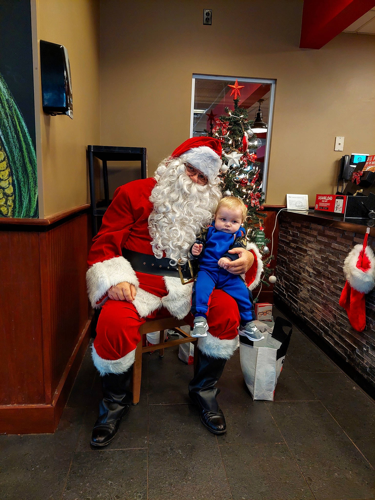 Lorenzo joined the competition — help win amazing prizes! boot, christmas, christmas_decoration, christmas_eve, christmas_ornament, costume, couch, event, fictional_character, fun, fur, hat, holiday, lap, living_room, person, picture_frame, room, santa_claus, toddler