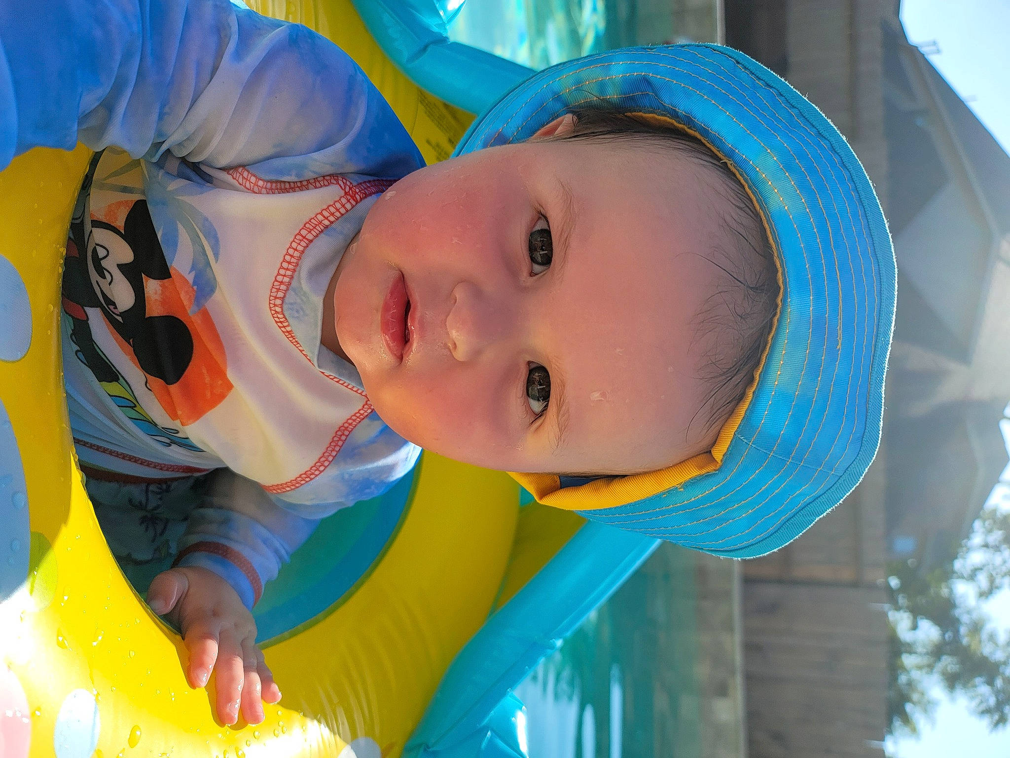 Bryson is registered to the contest to win money with this photo: azure, baby, blue, electric_blue, fun, happy, hat, headgear, leisure, mouth, nose, organ, person, recreation, skin, smile, sun_hat, toddler, tree, water