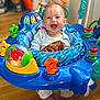 Victoire a rejoint le concours — aidez-le/la à gagner de superbes lots ! baby, smiling, blue, toy, activity_center, happy, infant, face, child, indoor, floor, colorful, playtime, clothing, legs, joy, cute, expression, seat, development