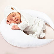 Dax is registered to the contest to win money with this photo: newborn, baby, sleeping, white_outfit, knit_hat, crescent_moon_pillow, soft_texture, cozy, infant, peaceful, cute, portrait, resting, indoors, baby_clothing, child, sleepwear, relaxation, serene, toddler