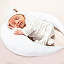 newborn, baby, sleeping, white_outfit, knit_hat, crescent_moon_pillow, soft_texture, cozy, infant, peaceful, cute, portrait, resting, indoors, baby_clothing, child, sleepwear, relaxation, serene, toddler