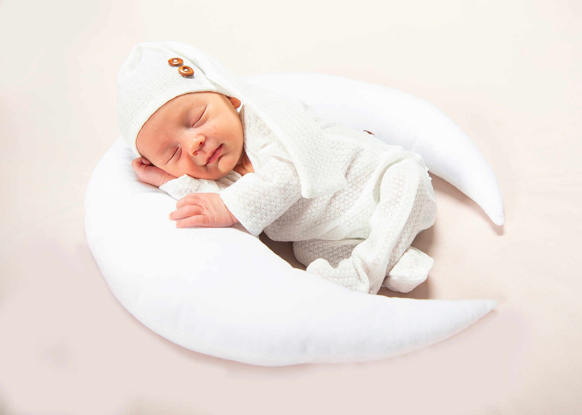 Dax is registered to the contest to win money with this photo: newborn, baby, sleeping, white_outfit, knit_hat, crescent_moon_pillow, soft_texture, cozy, infant, peaceful, cute, portrait, resting, indoors, baby_clothing, child, sleepwear, relaxation, serene, toddler