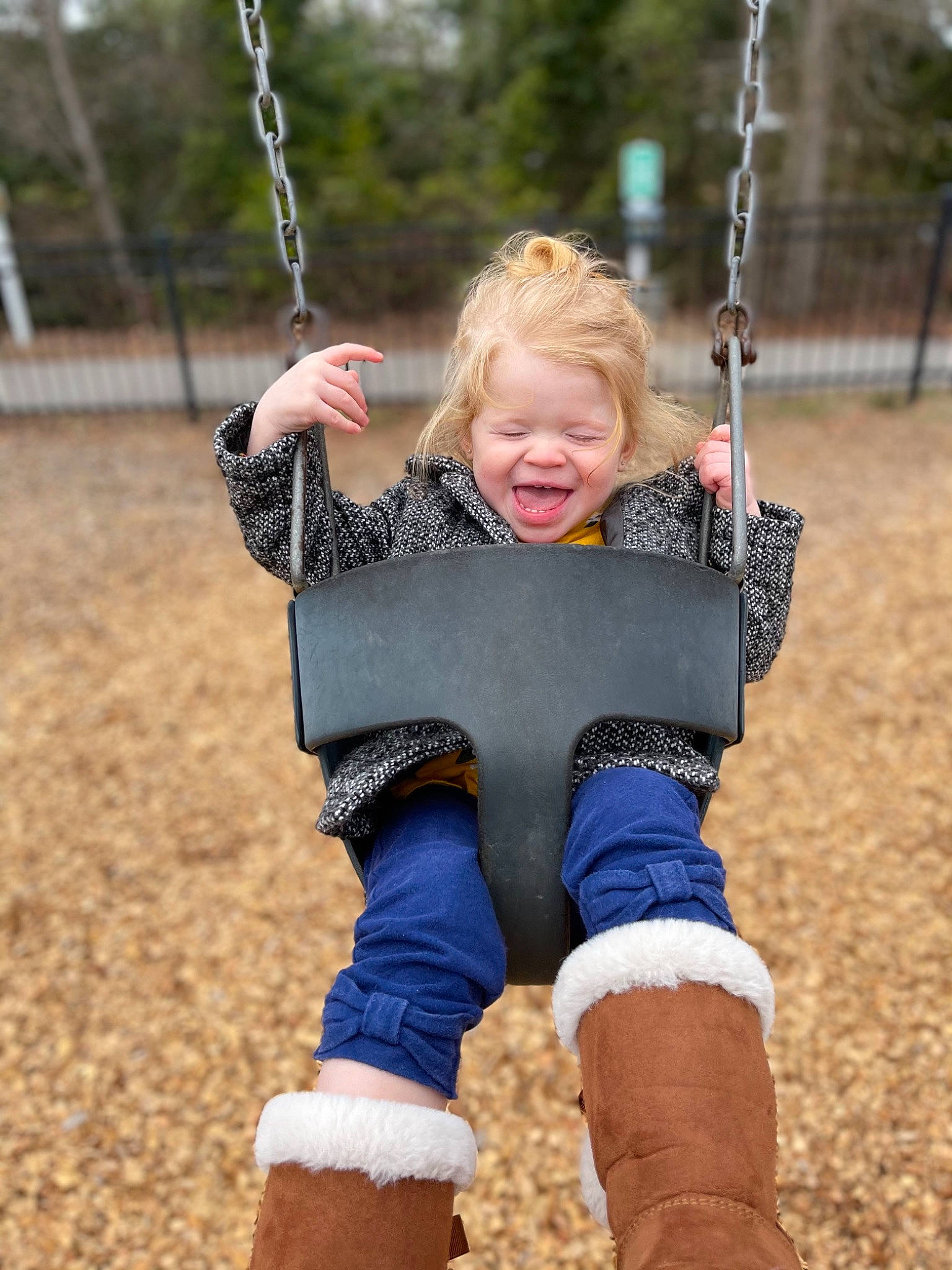 Madeline is registered to the contest to win money with this photo: black, blue, eye, face, grass, hair, happy, head, human_body, light, nature, person, photograph, playground, skin, sleeve, smile, swing, toddler, tree