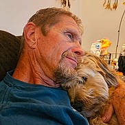 Tripper joined the competition — help win amazing prizes! man, dog, hugging, couch, indoor, smile, pet, closeup, beard, furry, affection, relaxation, casual_clothing, lamp, table, can, hand, expression, comfort, home