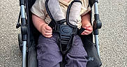 Josiah is registered to the contest to win money with this photo: baby, stroller, child, smiling, outdoor, pavement, barefoot, clothing, safety_harness, footrest, person, infant, cute, happy, seat, casual, young_child, playful, daylight, portrait