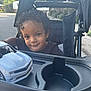 Lahiam joined the competition — help win amazing prizes! toddler, child, curly_hair, stroller, toy_car, outdoor, daylight, suburban, street, smile, face, black_clothing, plastic, cup_holder, play, baby, person, transport, vehicle, curious