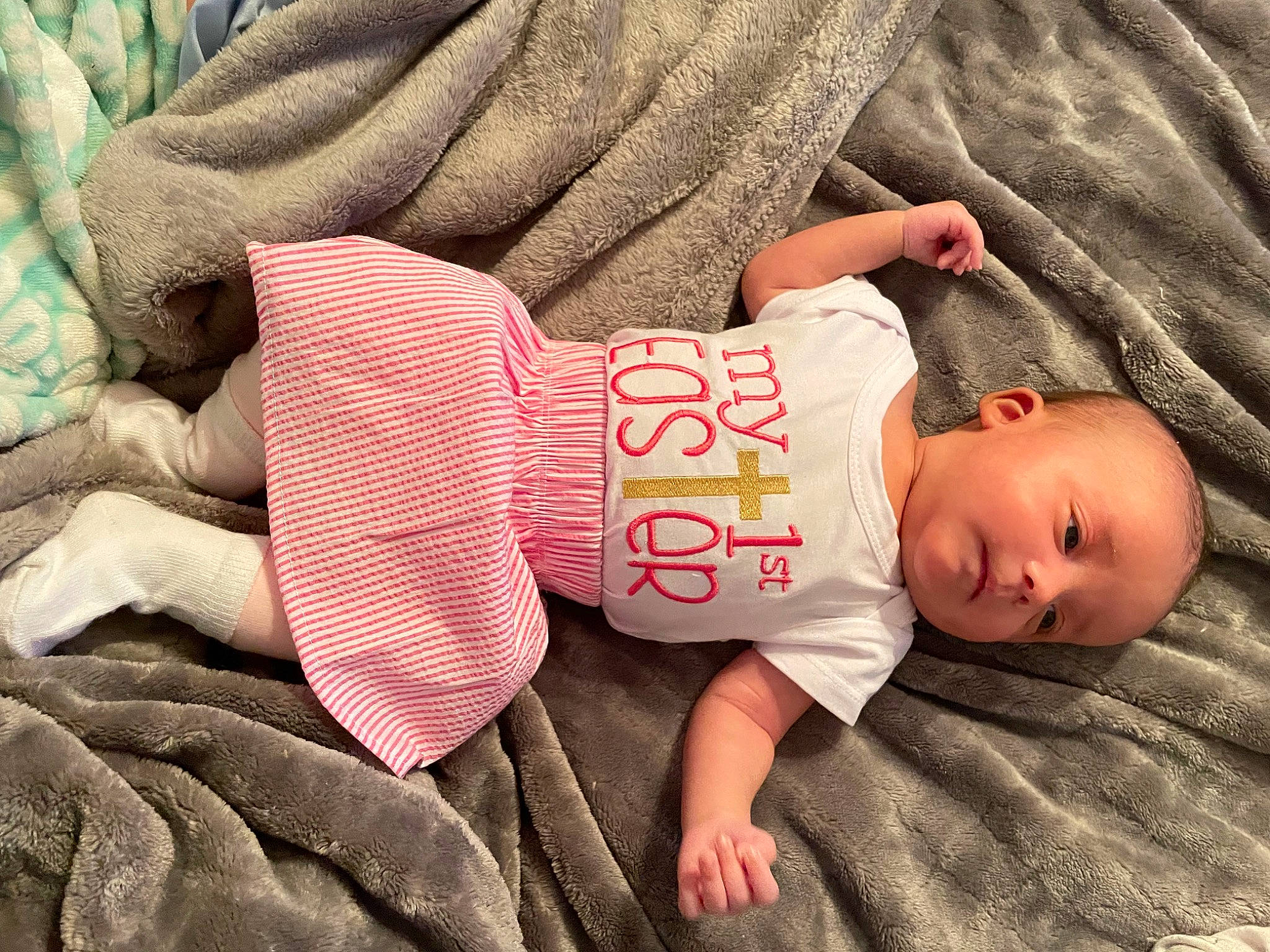 Alena is registered to the contest to win money with this photo: arm, baby, baby_toddler_clothing, cheek, child, comfort, finger, grass, hand, human_body, linens, nail, pattern, person, product, skin, sleeve, t_shirt, textile, toddler