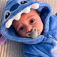 Hector a rejoint le concours — aidez-le/la à gagner de superbes lots ! adorable, baby, baby_clothes, blue_onesie, child, costume, cute, expression, eyes, face, headwear, hooded_clothing, indoors, infant, lying_down, pacifier, plush_texture, portrait, soft_fabric, stitch_costume