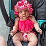 baby, child, stroller, hat, sunhat, swimsuit, pink_clothing, strawberry_pattern, cute, chubby_arms, chubby_legs, summer, outdoor, seat, infant, person, looking_at_camera, skin, footwear_absent, plump