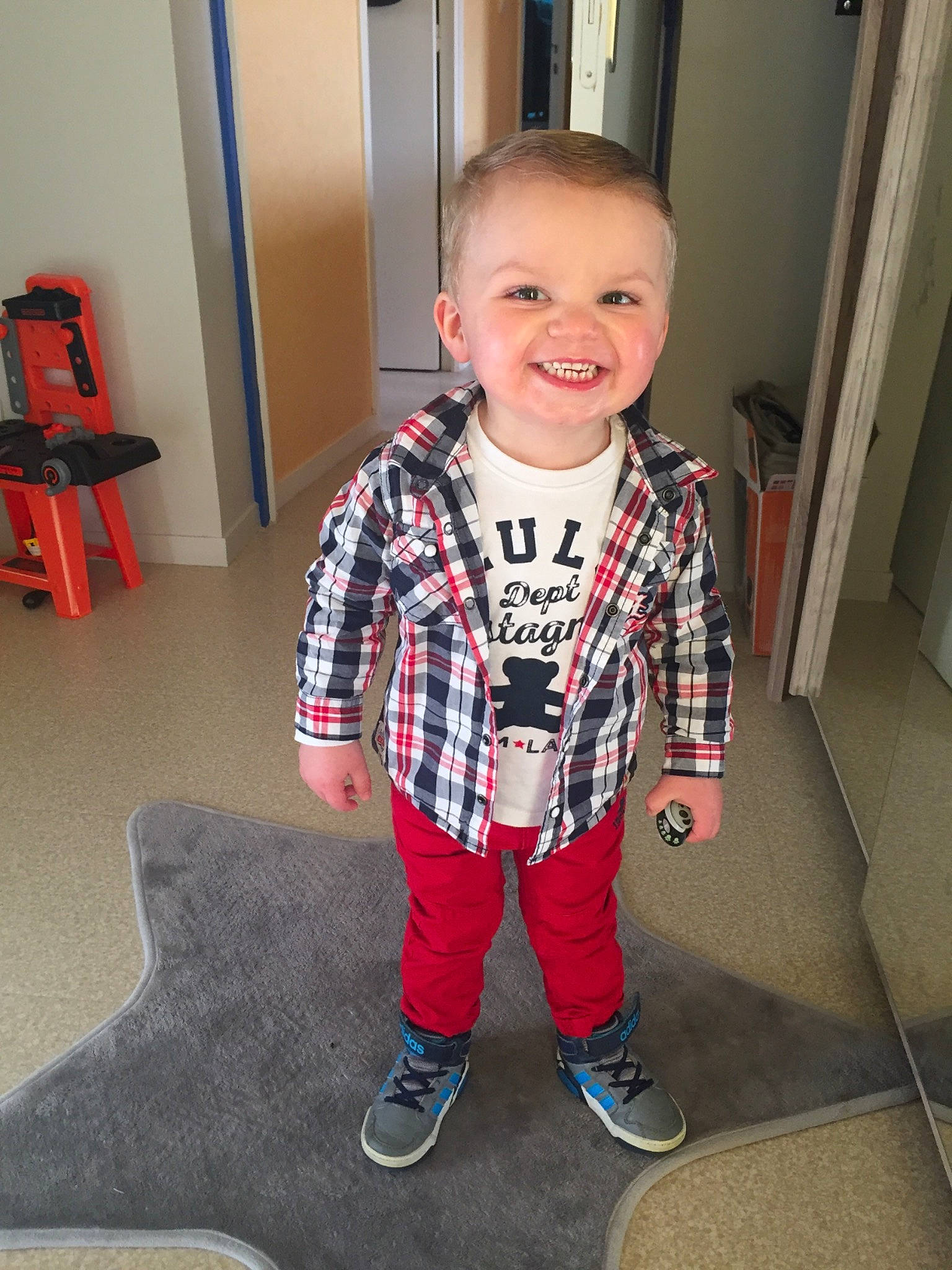 Léo participe au concours pour gagner de l'argent avec cette photo : cheek, child, design, joy, outerwear, pajamas, pattern, person, plaid, sleeve, smile, standing, t_shirt, tartan, textile, toddler