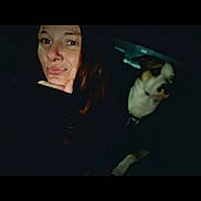 Pip is registered to the contest to win money with this photo: animal, blurred_background, casual, chin, companion, dark, dog, expression, face, friendship, hair, hand, indoor, looking, night, people, pet, portrait, selfie, woman