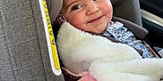 Adèle a rejoint le concours — aidez-le/la à gagner de superbes lots ! baby, child, car_seat, blanket, smile, face, window, car, interior, clothing, pink, white, fur, cute, infant, seatbelt, hair_clip, happy, portrait, young_child