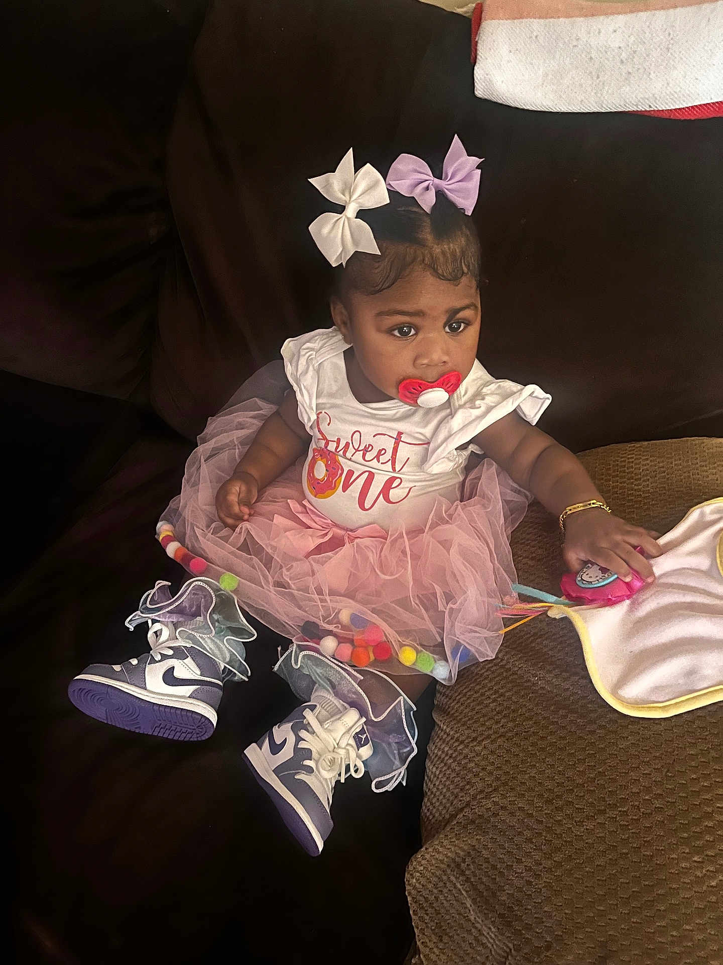 Mckenzie joined the competition — help win amazing prizes! toddler, girl, pacifier, pink_tutu, bows, sneakers, toy, couch, cushions, blanket, bracelet, indoor, child, cute, fashion, seated, looking_away, clothing, footwear, playful