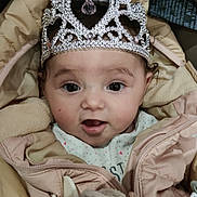 Tiana participe au concours pour gagner de l'argent avec cette photo : baby, child, tiara, jacket, coat, face, eyes, mouth, clothing, cute, infant, expression, portrait, young_child, indoors, soft_toy, warm, pink, headwear, adorable