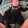 Cassie is registered to the contest to win money with this photo: baby, infant, black_clothing, tutu, headband, pink_flower, blanket, patterned_tights, sneakers, legs, person, indoor, cute, fashion, laying_down, soft_texture, curious_expression, casual, cozy, child