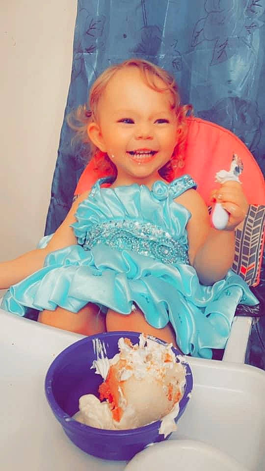 Kinsley is registered to the contest to win money with this photo: aqua, baby_toddler_clothing, blue, cake, cake_decorating, chair, child, dessert, dress, event, food, happy, icing, joy, person, pink, recipe, smile, sugar_cake, sweetness