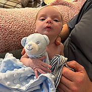 Enzo joined the competition — help win amazing prizes! baby, infant, blanket, stuffed_toy, teddy_bear, hand, person, couch, plaid_chair, fabric, soft_texture, indoor, closeup, holding, comfort, newborn, skin, face, adult, cozy