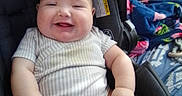 Braik is registered to the contest to win money with this photo: baby, backpack, blanket, buckle, car_seat, cheeks, chubby, clothing, diaper, hands, happy, indoors, infant, legs, onesie, plush_blanket, portrait, seat_pad, sitting, smiling