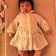 Iris a rejoint le concours — aidez-le/la à gagner de superbes lots ! baby, infant, child, towel, dress, clothing, pink_pants, floral_pattern, lying_down, tongue_out, hair, cute, indoor, wooden_surface, face, skin, hand, foot, fabric, soft_texture