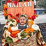 Nailah is registered to the contest to win money with this photo: baby, child, smiling, basket, blanket, pumpkin, autumn, fall_leaves, headband, outdoor, decor, wooden_sign, happy, cute, person, seasonal, nature, greenery, portrait, cozy