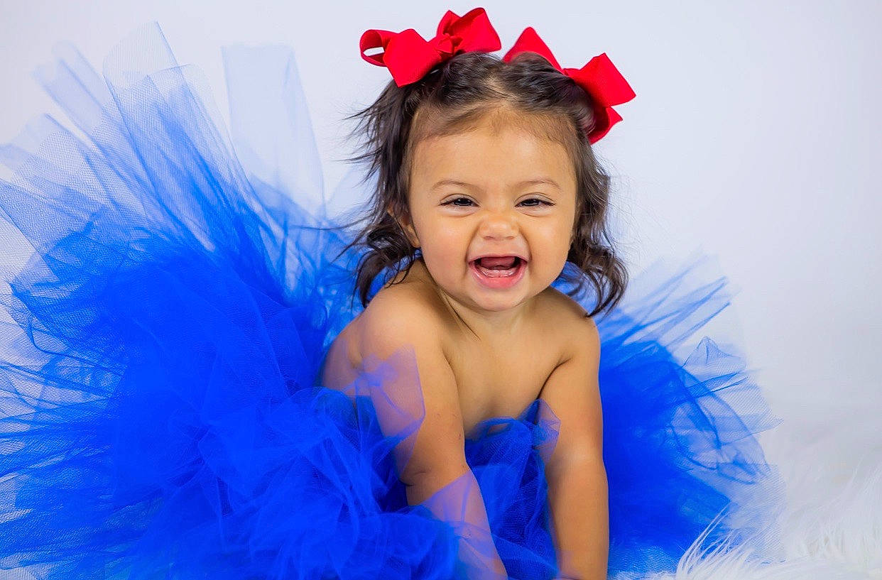 Amilia is registered to the contest to win money with this photo: baby, ballet_tutu, blue, child, child_model, costume, costume_accessory, face, feather_boa, fun, hair_accessory, headband, headpiece, joy, person, photo_shoot, photography, pink, product, smile