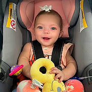 Xzanna is registered to the contest to win money with this photo: baby, car_seat, child, smiling, toy, plush_toy, pink, gray, white_bow, colorful_pants, infant, happy, cute, seatbelt, playful, feet, blue_eyes, indoors, holding, young_child