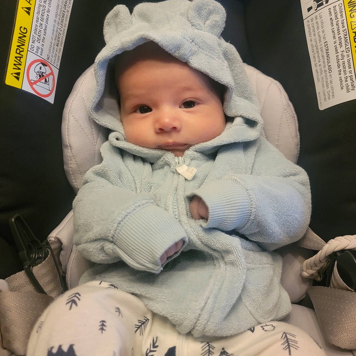Julian is registered to the contest to win money with this photo: baby, baby_carriage, baby_products, baby_safety, baby_sleeping, baby_toddler_clothing, cap, cheek, child, comfort, eyelash, fashion_accessory, fur, headwear, knit_cap, linens, person, sitting, sleeve, toddler