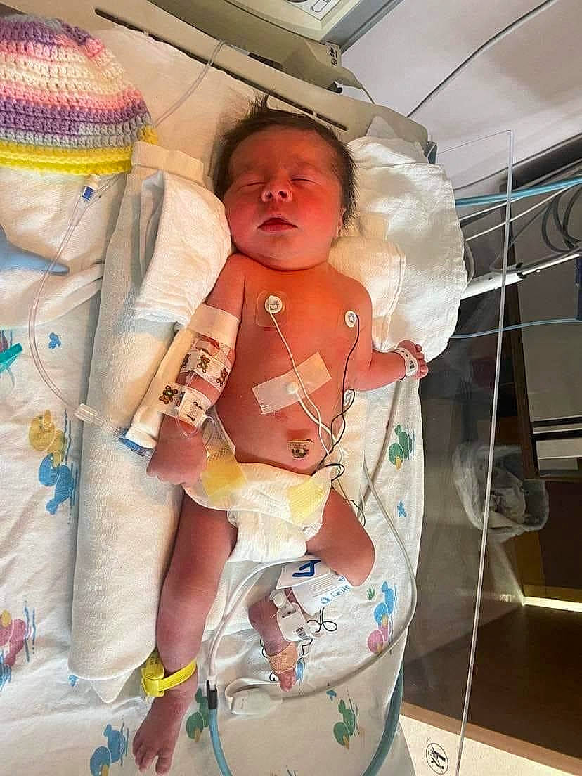 Lakelyn is registered to the contest to win money with this photo: abdomen, baby, baby_sleeping, baby_toddler_clothing, chest, child, doll, fun, hat, hospital, human_body, human_leg, pattern, peach, person, room, service, skin, stuffed_toy, thigh