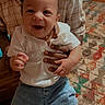 Ezekiel joined the competition — help win amazing prizes! baby, child, infant, smiling, happy, portrait, face, person, indoors, clothing, white_shirt, jeans, held, adult_hand, home, carpet, furniture, sitting, photograph, close_up
