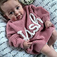 Kash joined the competition — help win amazing prizes! baby, infant, child, pink_sweater, knitted_clothing, blanket, milestone_disc, fox_illustration, big_eyes, portrait, indoors, cute, smiling, laying, hand, legs, soft_texture, closeup, skin, nursery