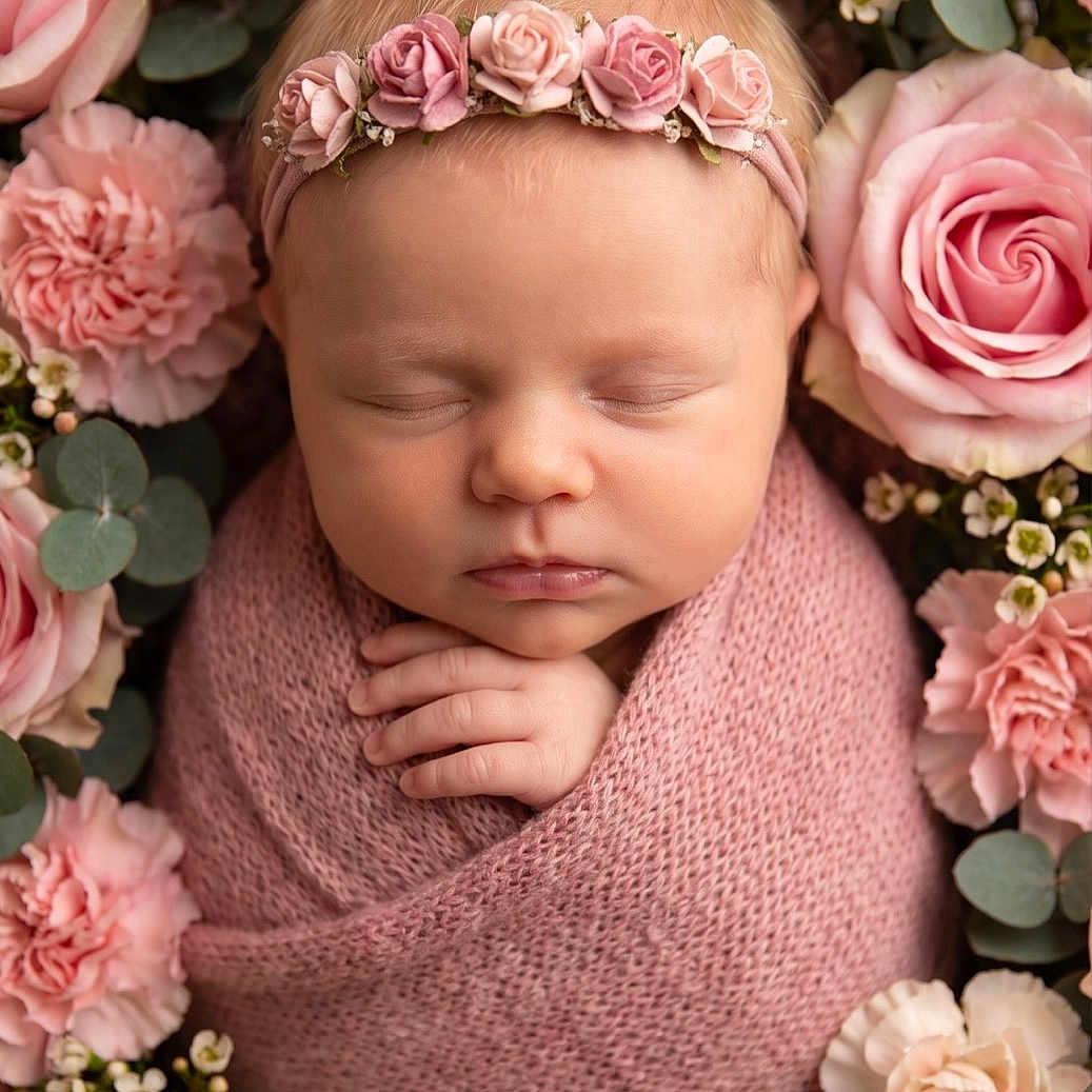 Luna is registered to the contest to win money with this photo: newborn, baby, sleeping, pink, blanket, flower_crown, roses, carnations, floral_arrangement, portrait, closeup, peaceful, soft_texture, headband, infant, cute, wrapped, hands, delicate, nature